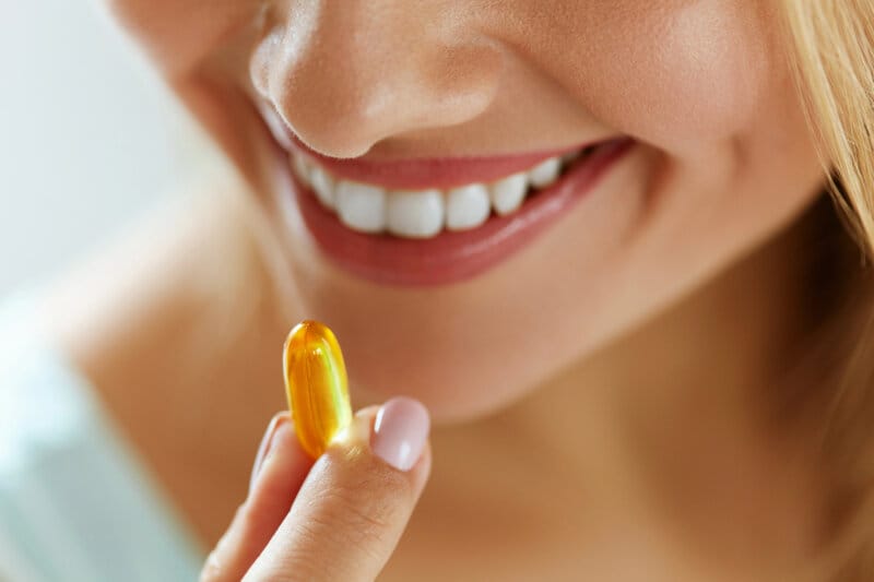 Junge Frau Nimmt Omega 3 Kapseln Ein.